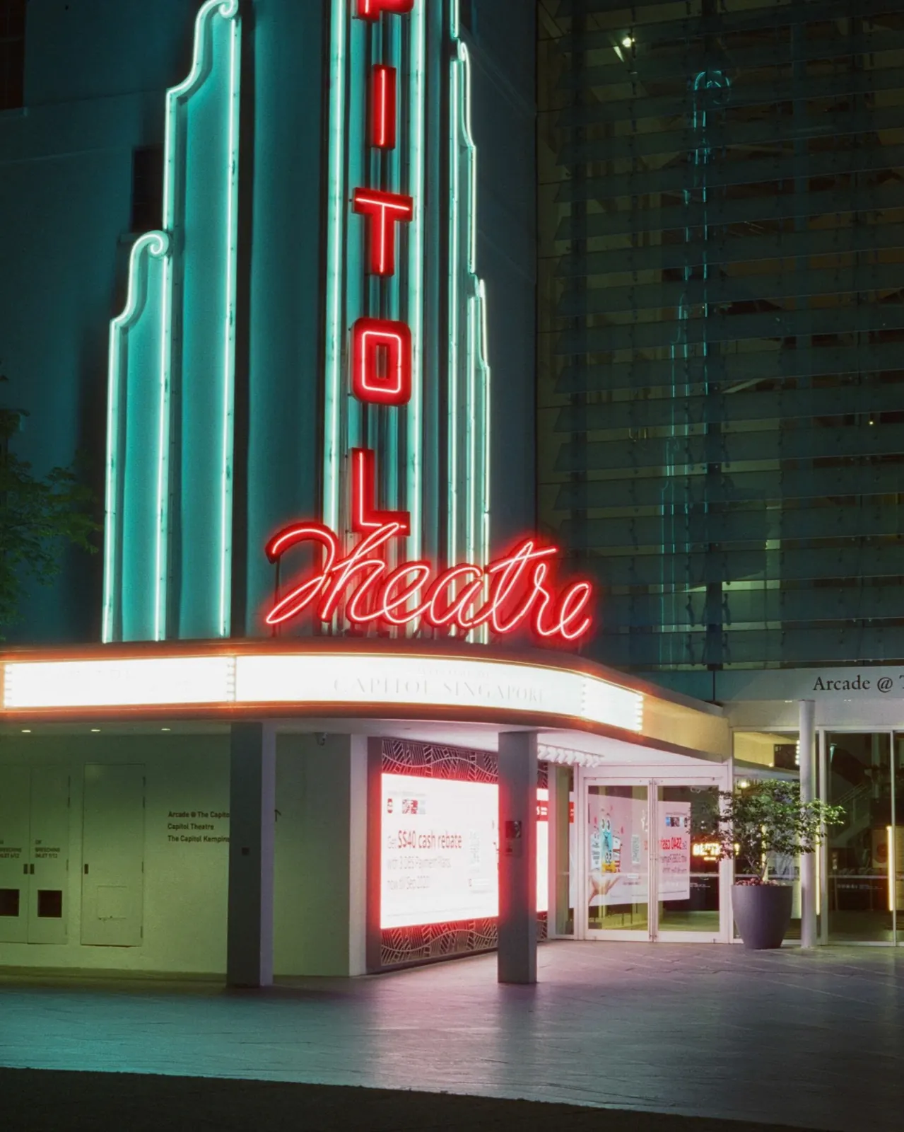 The neon Capitol Theatre sign glowing against the building at dusk, Singapore