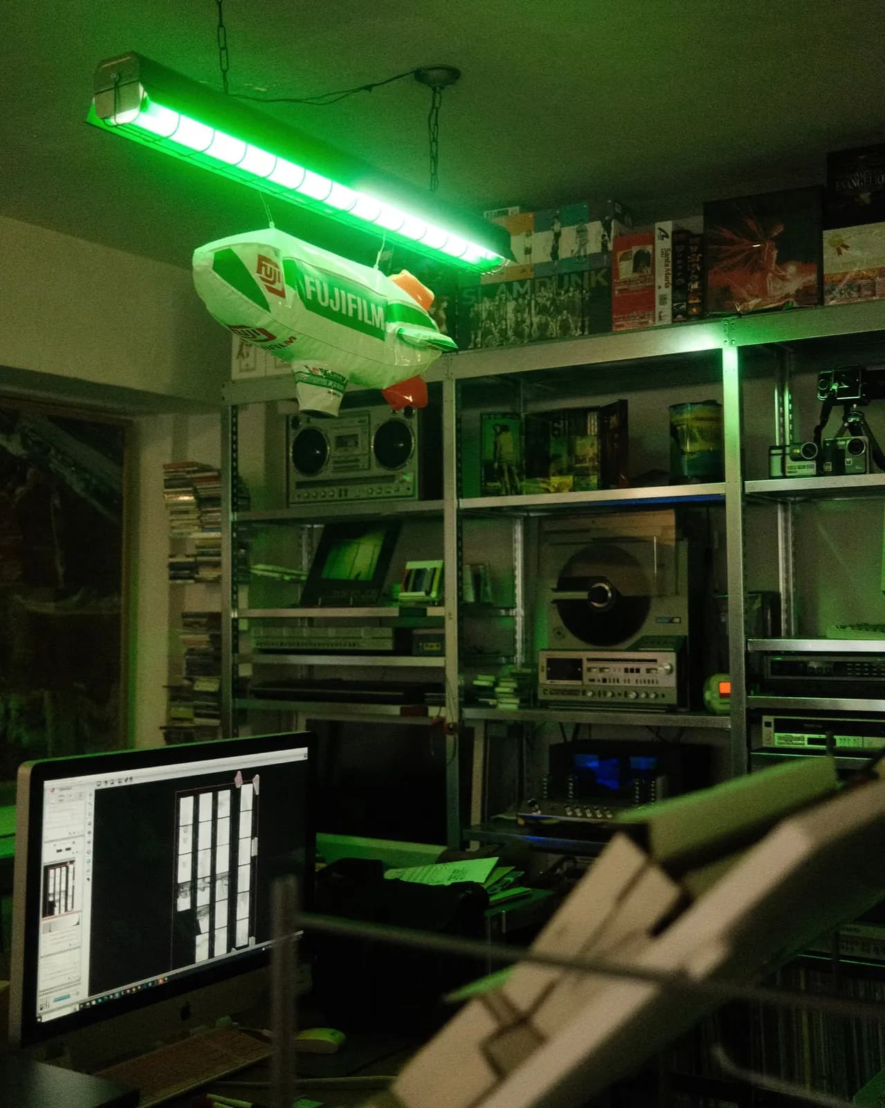 Interior of a film lab at night, shelves of equipment under green light